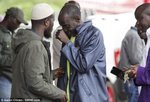 A brother of one of the victims sheds a tear as rescue officers work to remove the bodies of the men after the tragedy 