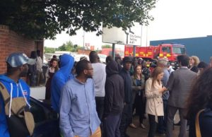 Dozens of onlookers are waiting outside the metal recycling plant for news